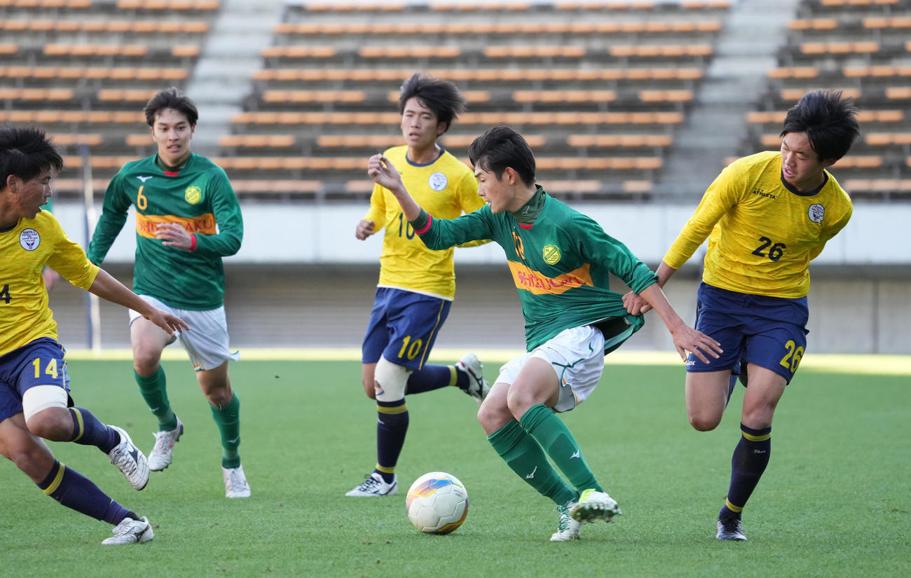 静岡学園対関東第一　前半、関東第一・倉持（右）にユニホームを引っ張られながらドリブル突破をはかる静岡学園・古川（撮影・小沢裕）