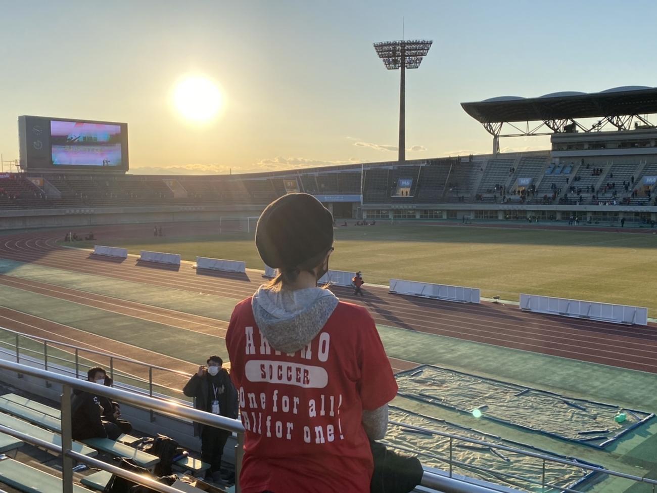 高校サッカー選手権1回戦の秋田商－東福岡の試合後、スタンドから誰もいないピッチを見つめる秋田商サッカー部の寮母・赤坂郁子さん