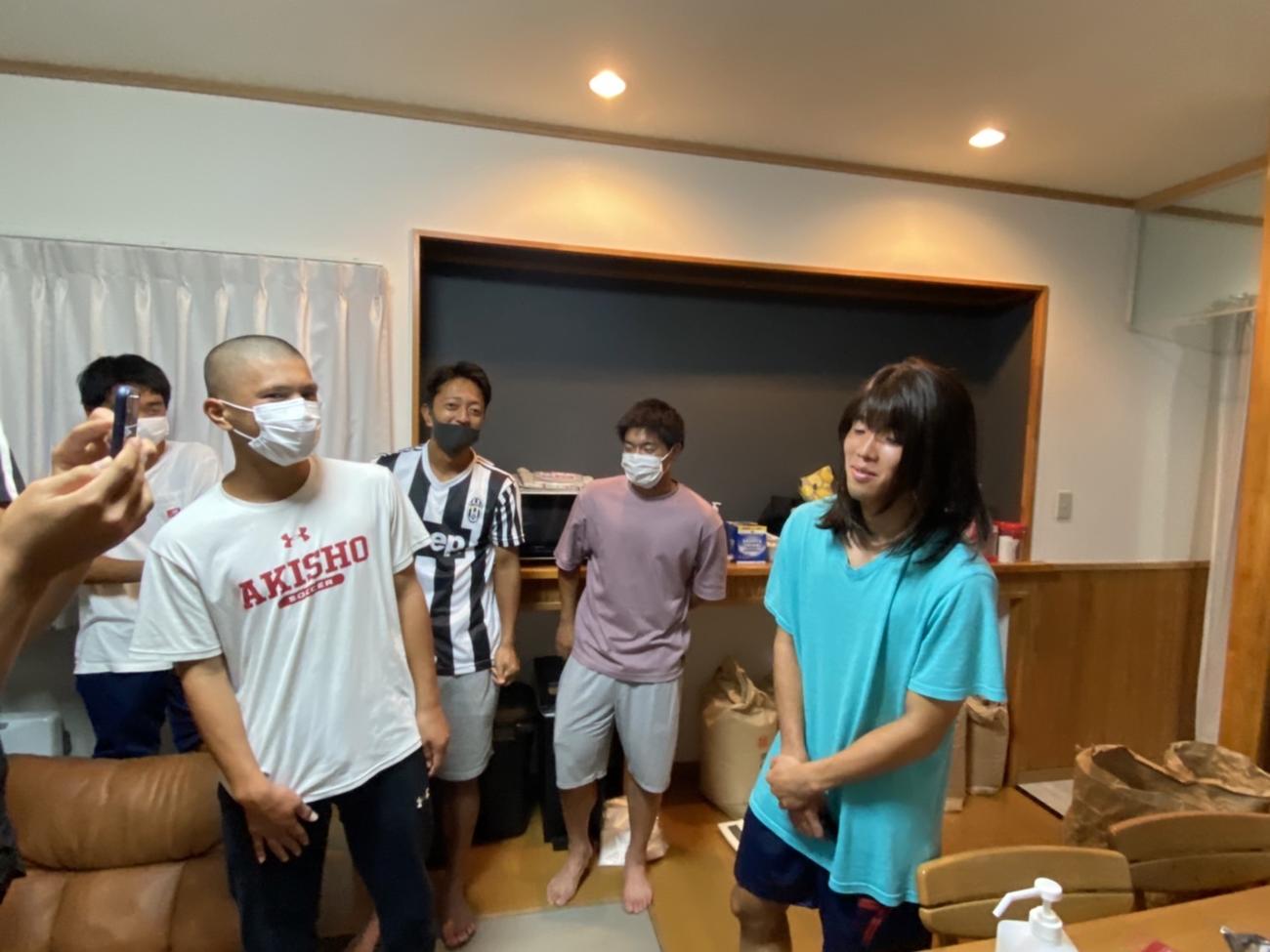 秋田商サッカー部の寮母・赤坂郁子さんが着用していたウィッグを被らせてもらう寮生