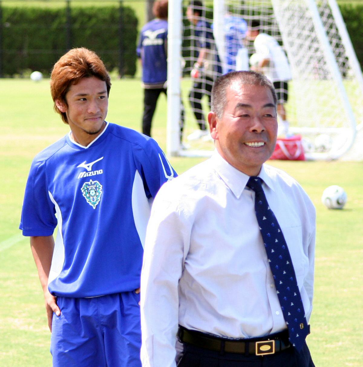 恩師の小嶺忠敏・国見高総監督（右）から激励を受け、テレ笑いする福岡DF中村北斗（06年9月22日撮影）