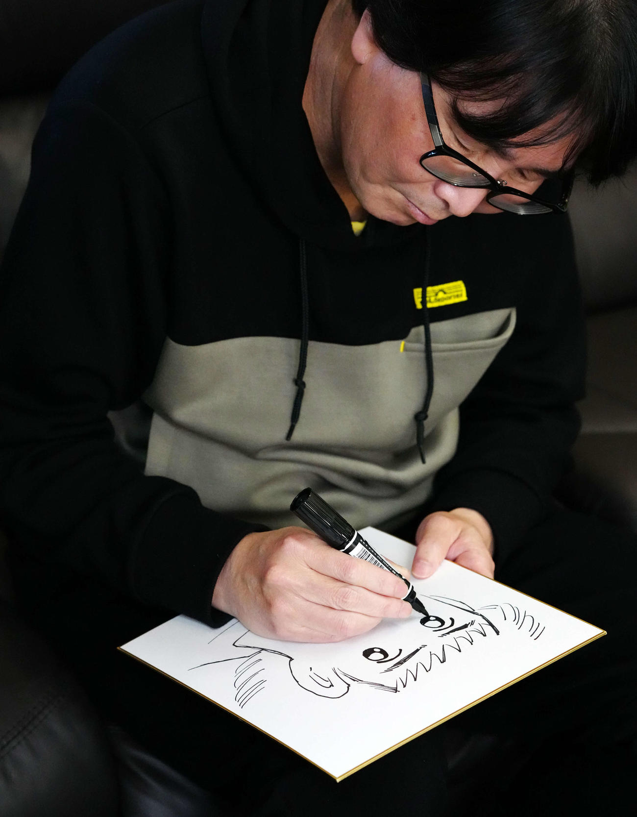 色紙に主人公である大空翼を描く高橋陽一氏（撮影・江口和貴）
