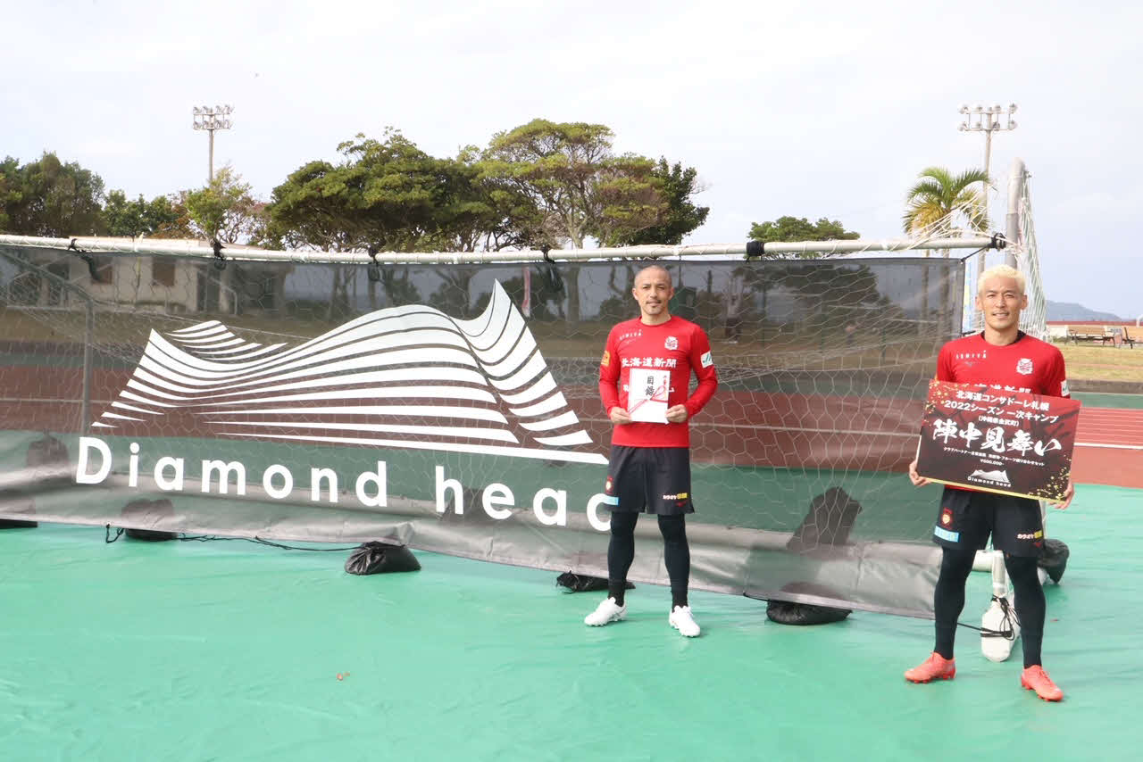 贈呈品を受け取るコンサドーレ札幌のMF小野（左）とGK菅野（C）2022 CONSADOLE
