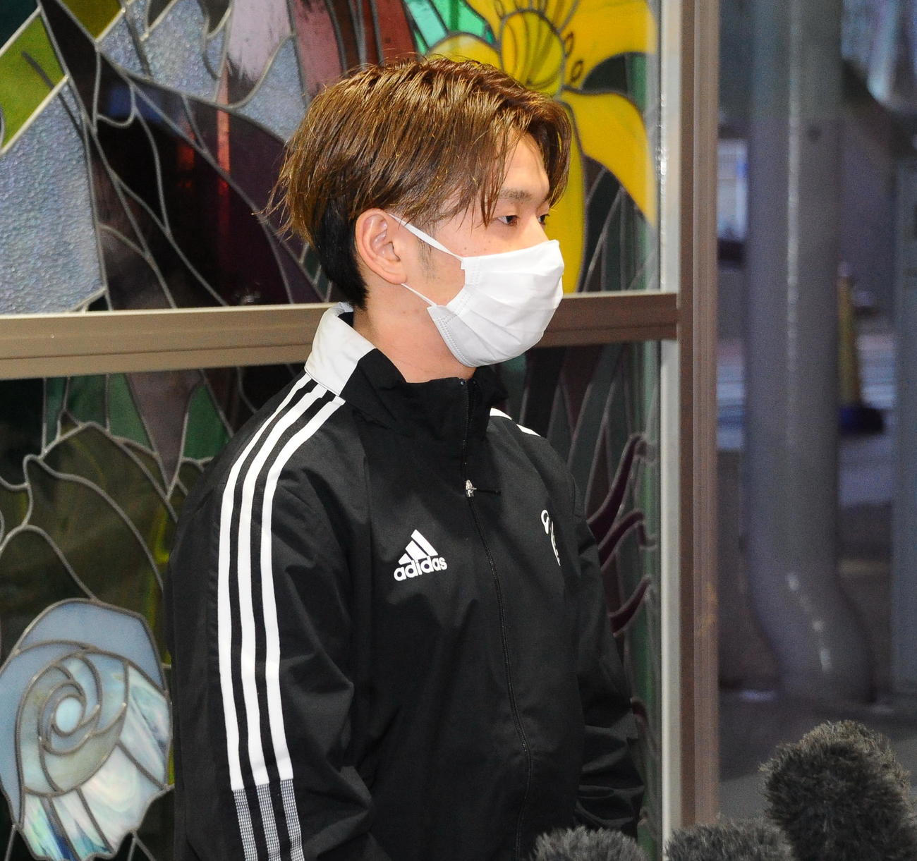 高知キャンプ出発前に報道陣からの質問に答える新潟の本間至恩