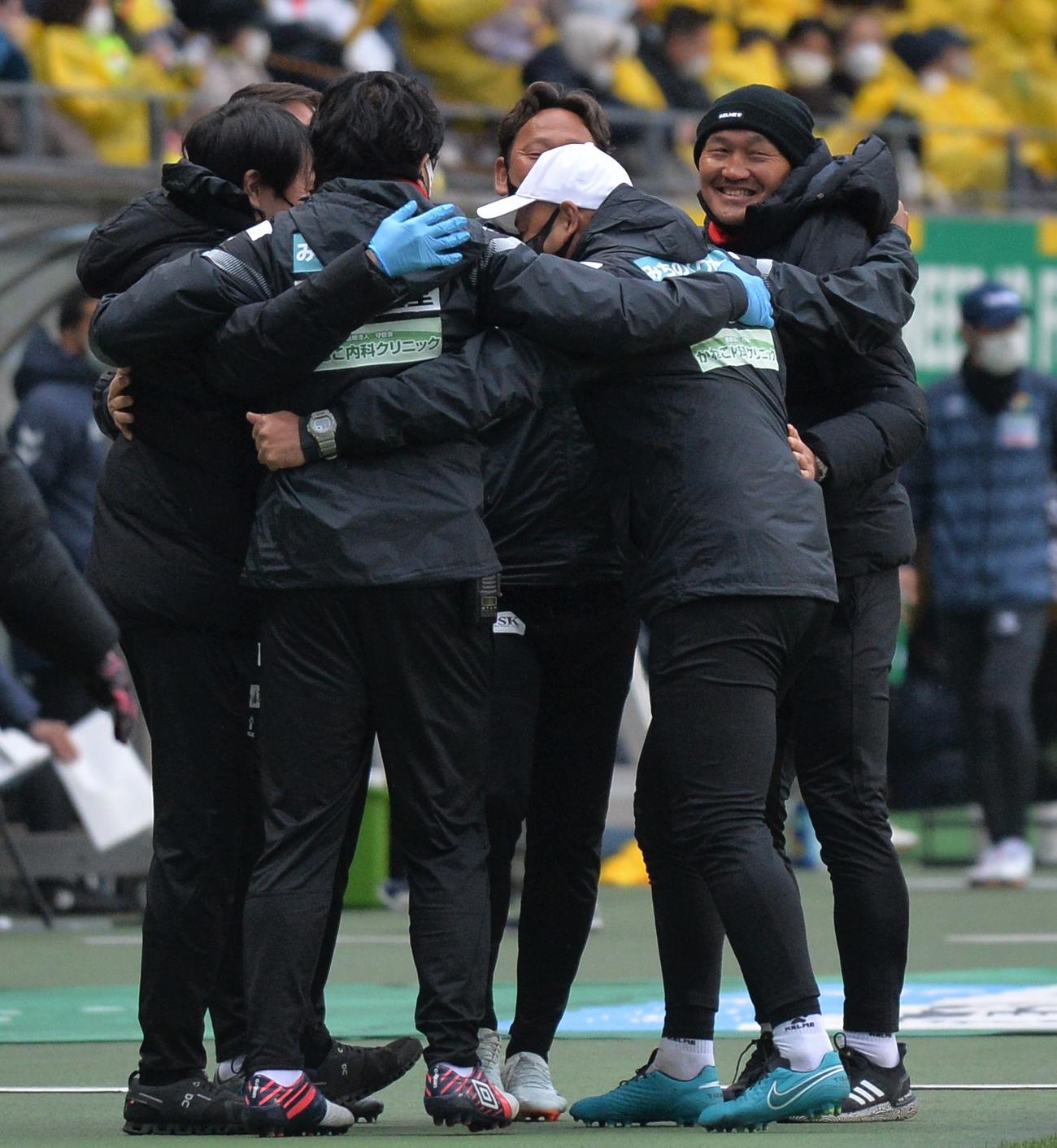 開幕戦に勝利し、笑顔で首脳陣と抱き合う秋田監督（右）