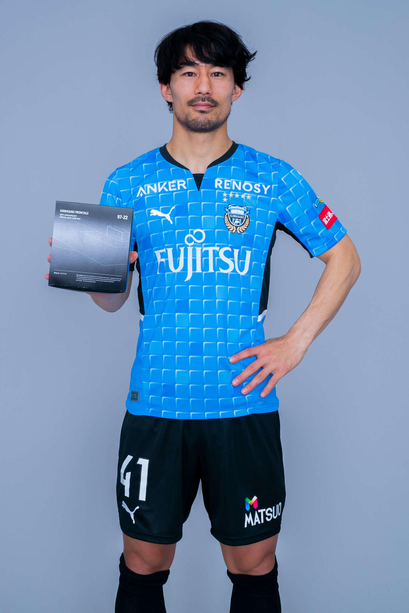 川崎がバルクオムとコラボレーションして発売するクラブ創立26周年記念グッズを持つMF家長　（C）KAWASAKIFRONTALE