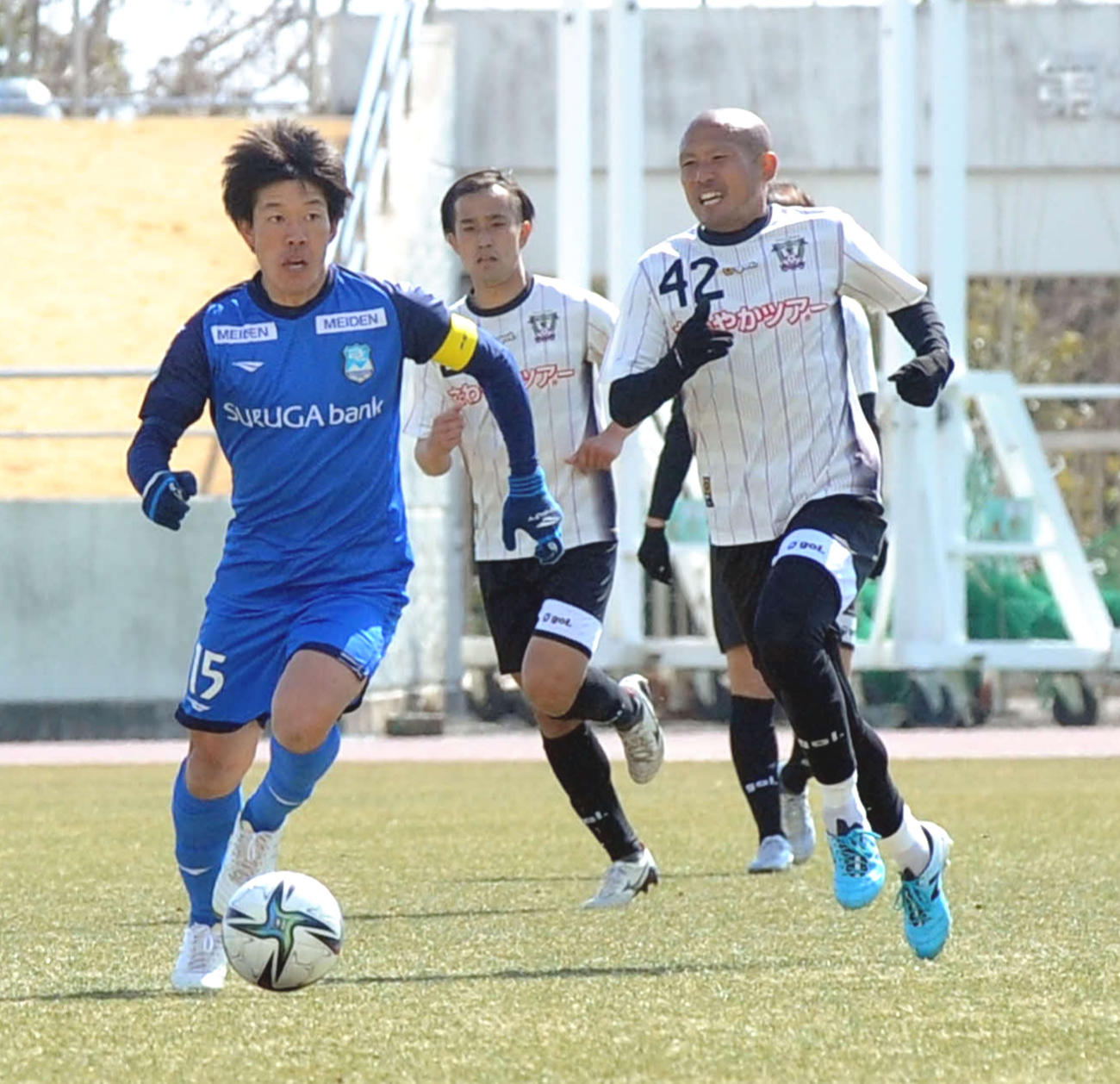 ドリブルで攻め上がる沼津菅井（左）