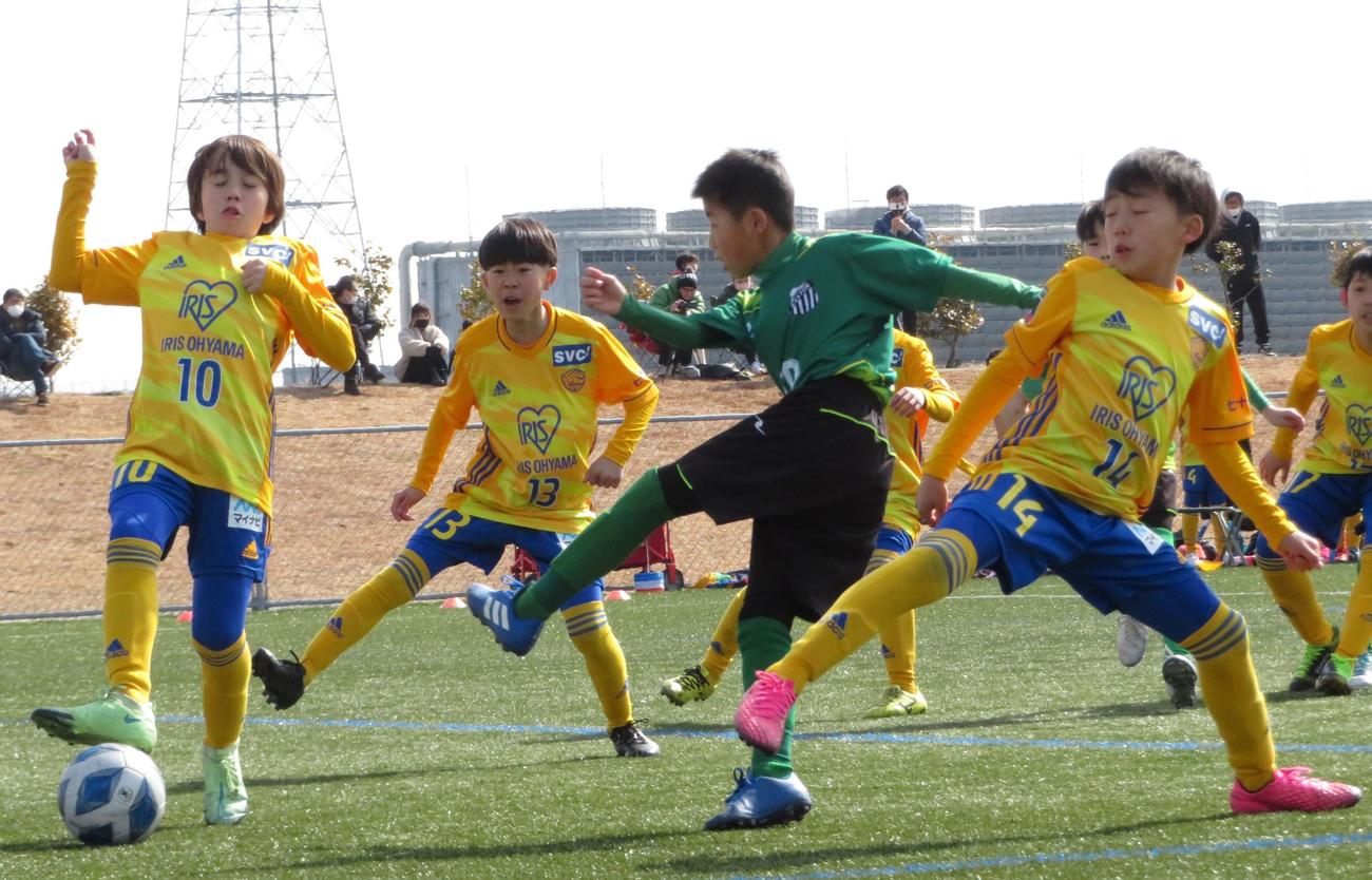 相手守備をかわしてシュートを放つ会津サントスFCの選手（中央）（撮影・峯岸佑樹）