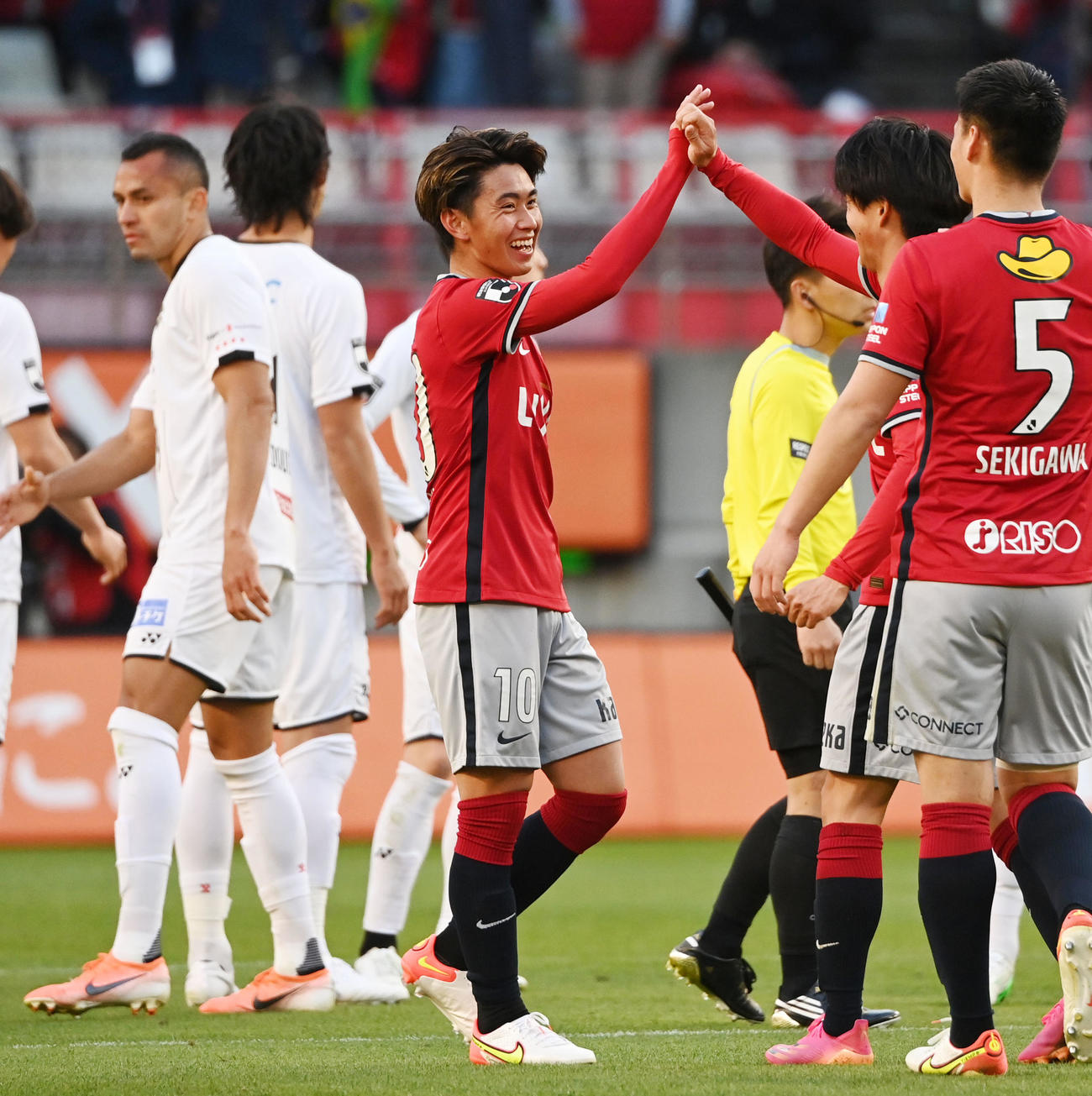 鹿島対柏　後半、柏に勝利し笑顔でチームメートとタッチを交わす鹿島荒木（中央）（撮影・横山健太）