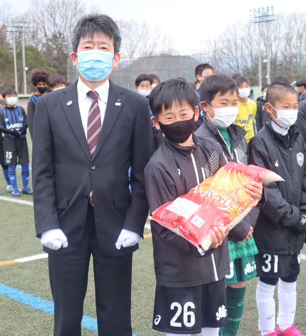 優勝チームに副賞を手渡したJA全農広報・調査部の新妻成一部長（左）