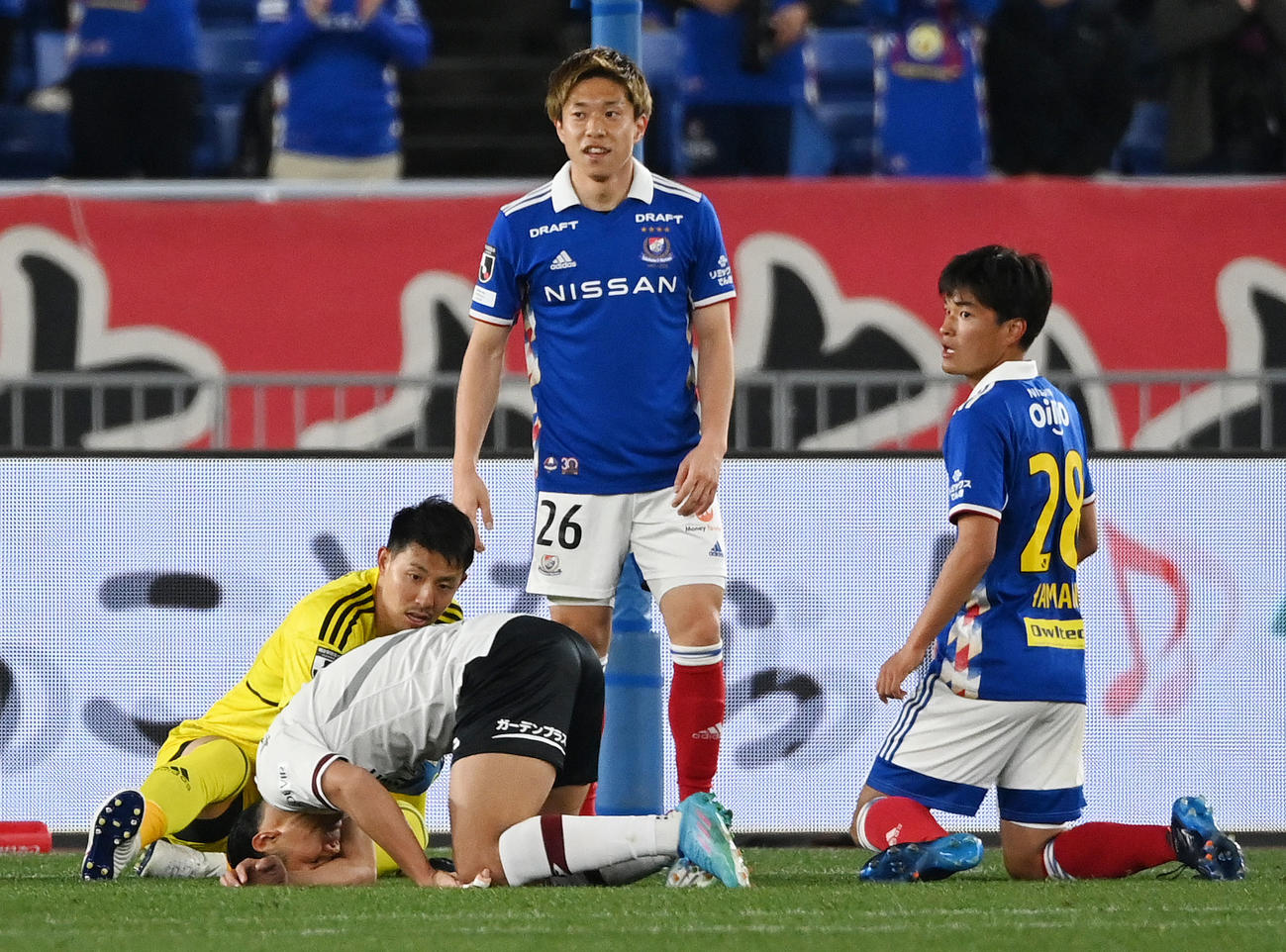 横浜対神戸　前半、足を押さえ倒れ込む神戸武藤（左から2人目）（2022年3月2日）