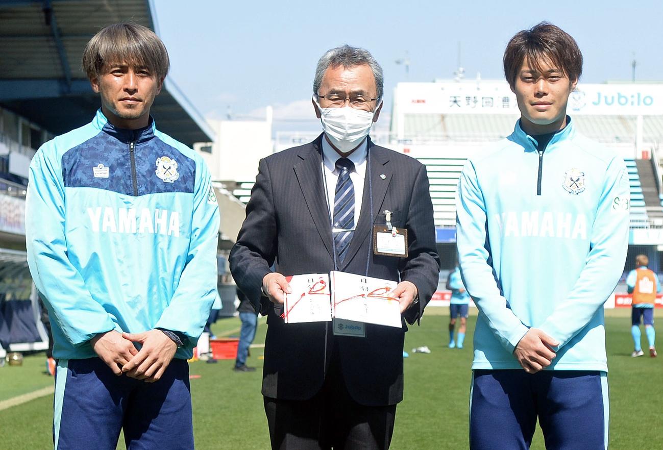 ヤマハスタジアムで贈呈式を行い、記念撮影する、左から磐田小川、磐田市の村松教育長、磐田松本