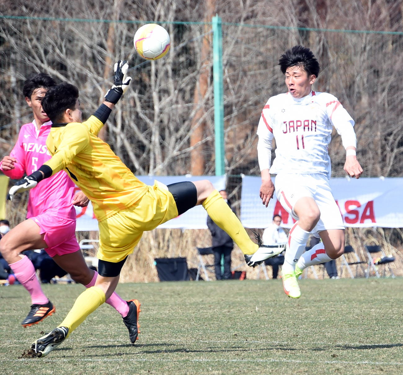 後半、ボールを浮かせて相手GK（中央）をかわす日本高校選抜MF藤森（右）