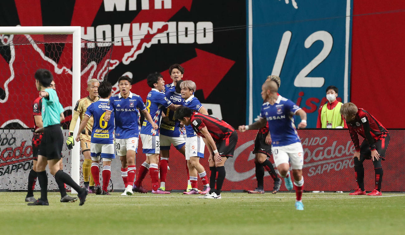 札幌対横浜　試合終了後、同点ゴールを決めチームメートと喜び合う横浜実藤（中央奥）と肩を落とす札幌イレブン（撮影・佐藤翔太）