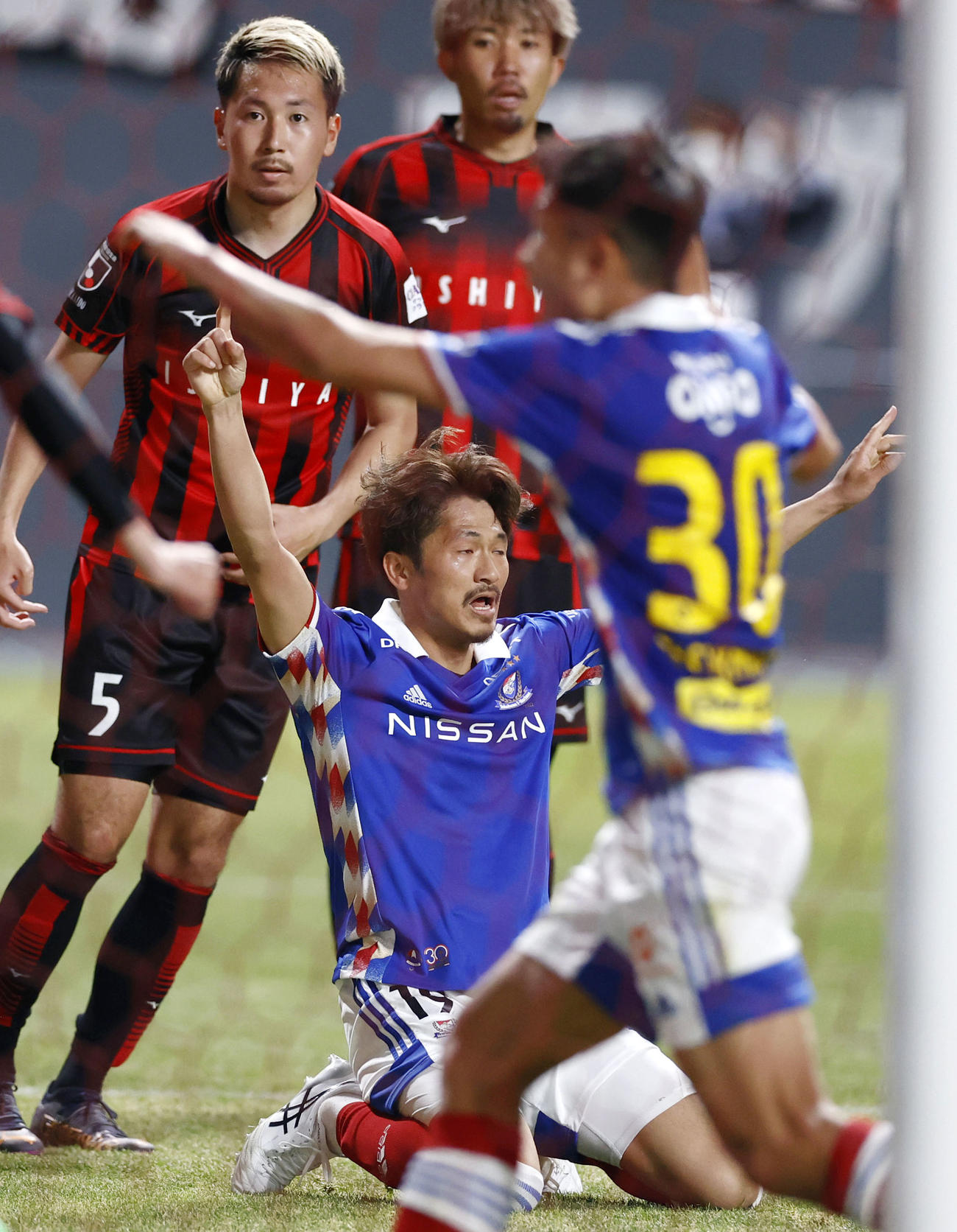 試合終了間際、同点ゴールを決め喜ぶ横浜M・実藤（下）（共同）