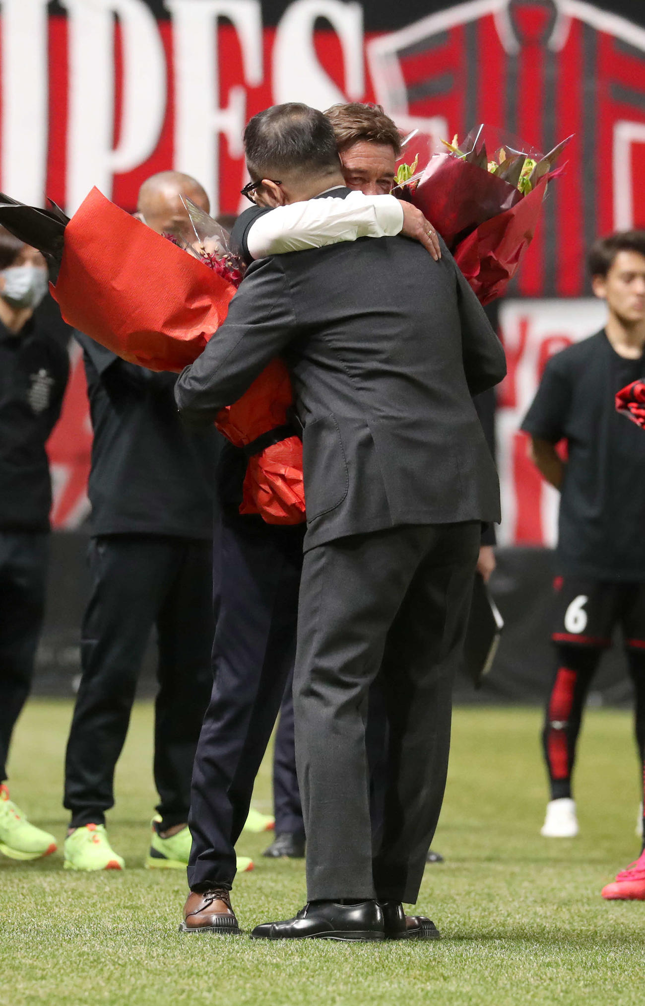 札幌対横浜　札幌ペトロビッチ監督（後方）は野々村会長とハグをする（撮影・佐藤翔太）