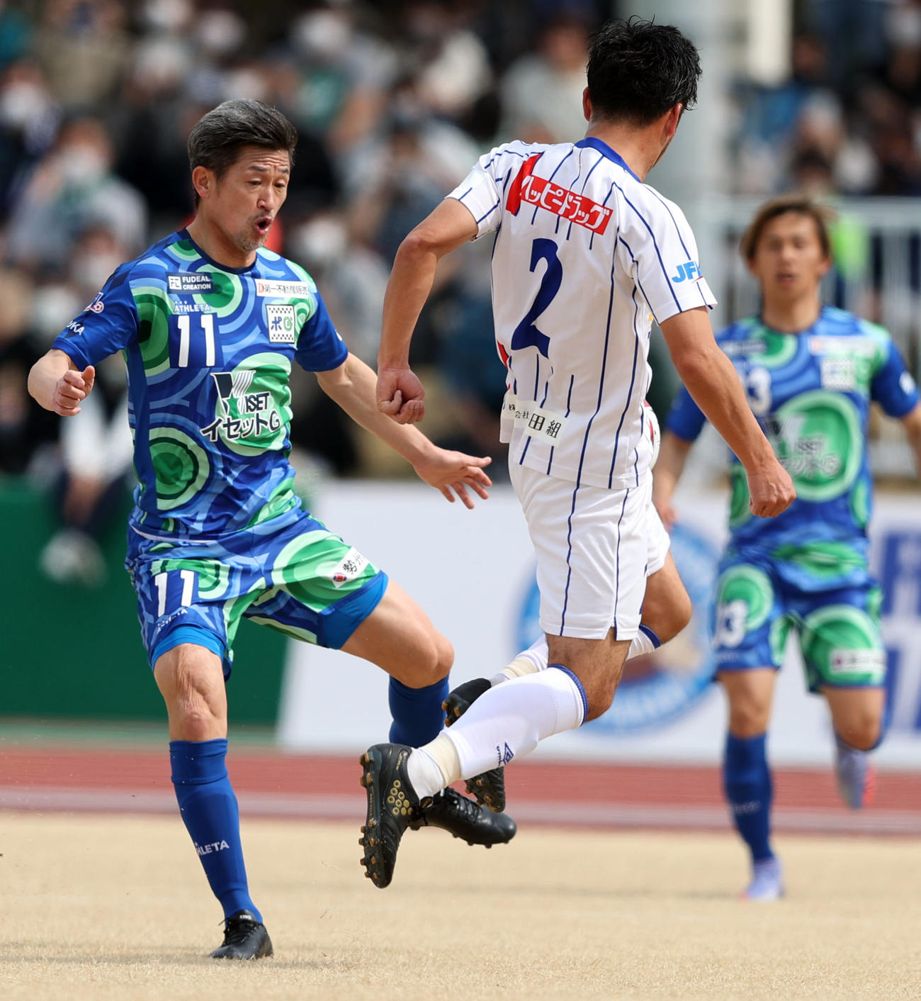 鈴鹿対青森　前半、相手と競り合う鈴鹿カズ（左）（撮影・狩俣裕三）