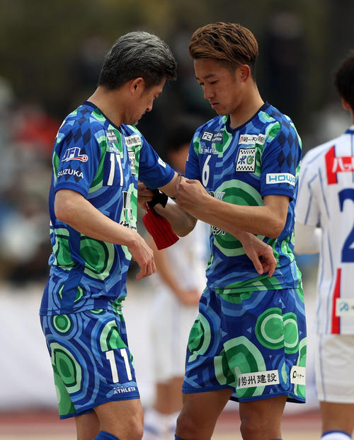 鈴鹿対青森　後半途中、キャプテンマークをつけてもらう鈴鹿カズ（左）（撮影・狩俣裕三）