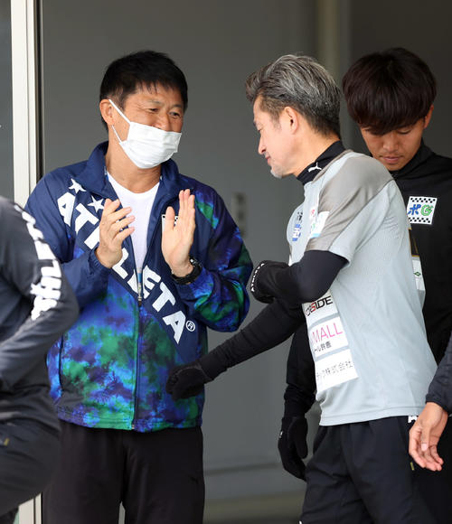 鈴鹿対青森　ウオーミングアップに出る鈴鹿カズ（右）を送り出す武田氏（撮影・狩俣裕三）