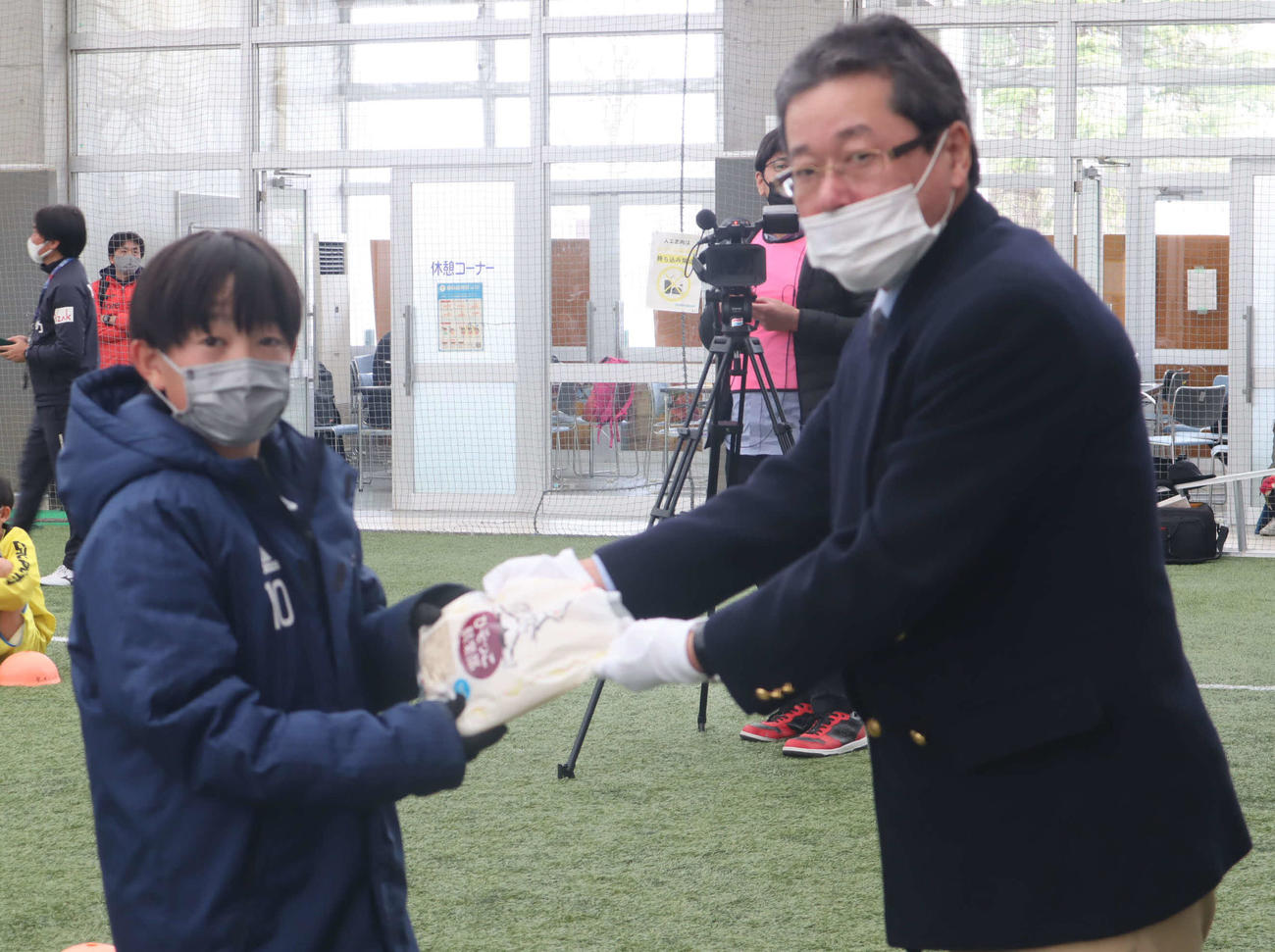 優勝チームに副賞を手渡すJA全農富山県本部の堀内弘和管理部地区担当部長（右）