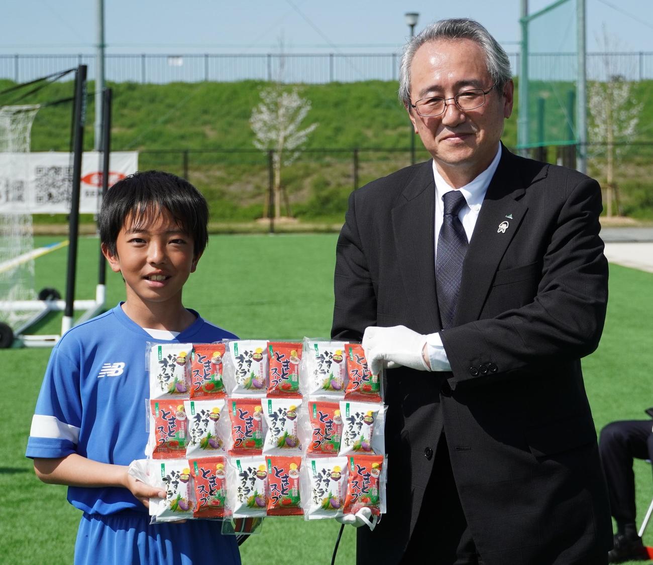 優勝チームに副賞を手渡す、JA全農福岡県本部の大坪康志県本部長（右）