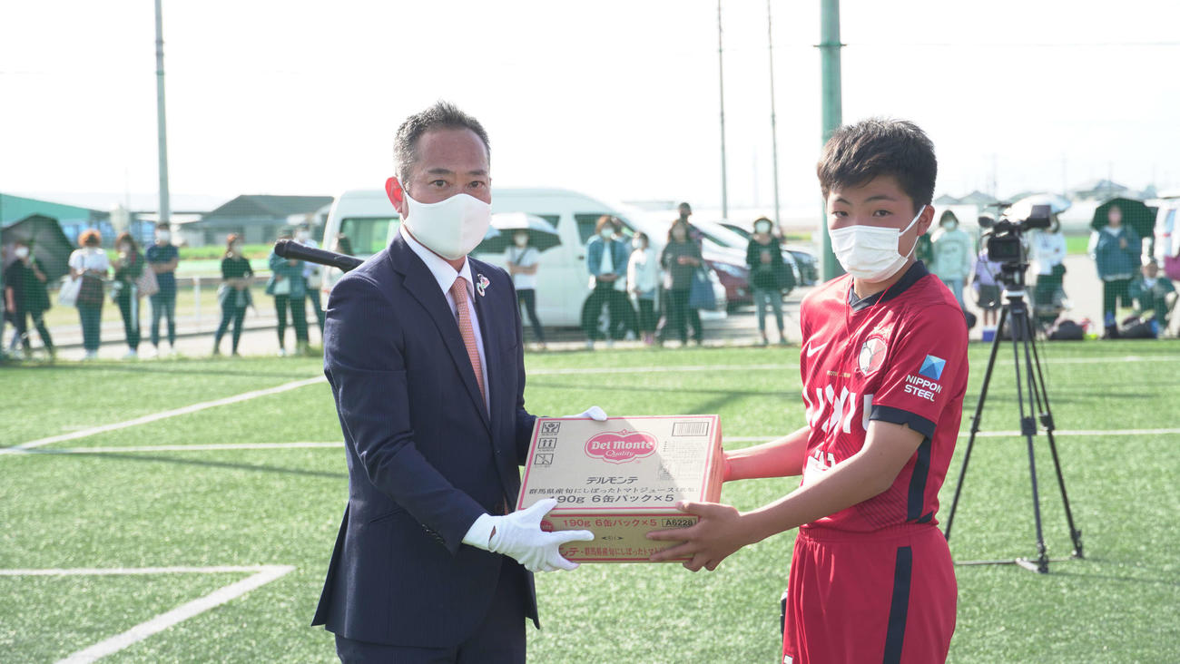優勝チームに副賞を手渡すJA全農群馬県本部の高田宗徳管理部長（左）