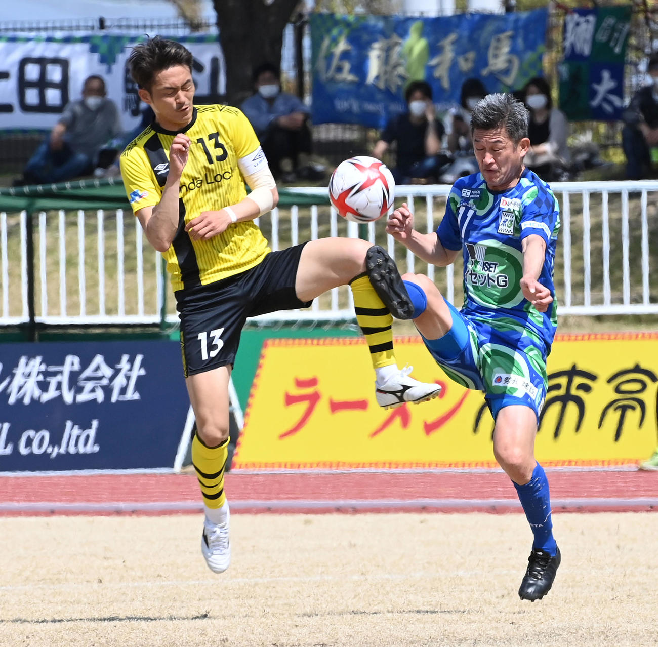 鈴鹿対ホンダロック　前半、ホンダロック高原（左）とボールを奪い合う鈴鹿カズ（撮影・前岡正明）