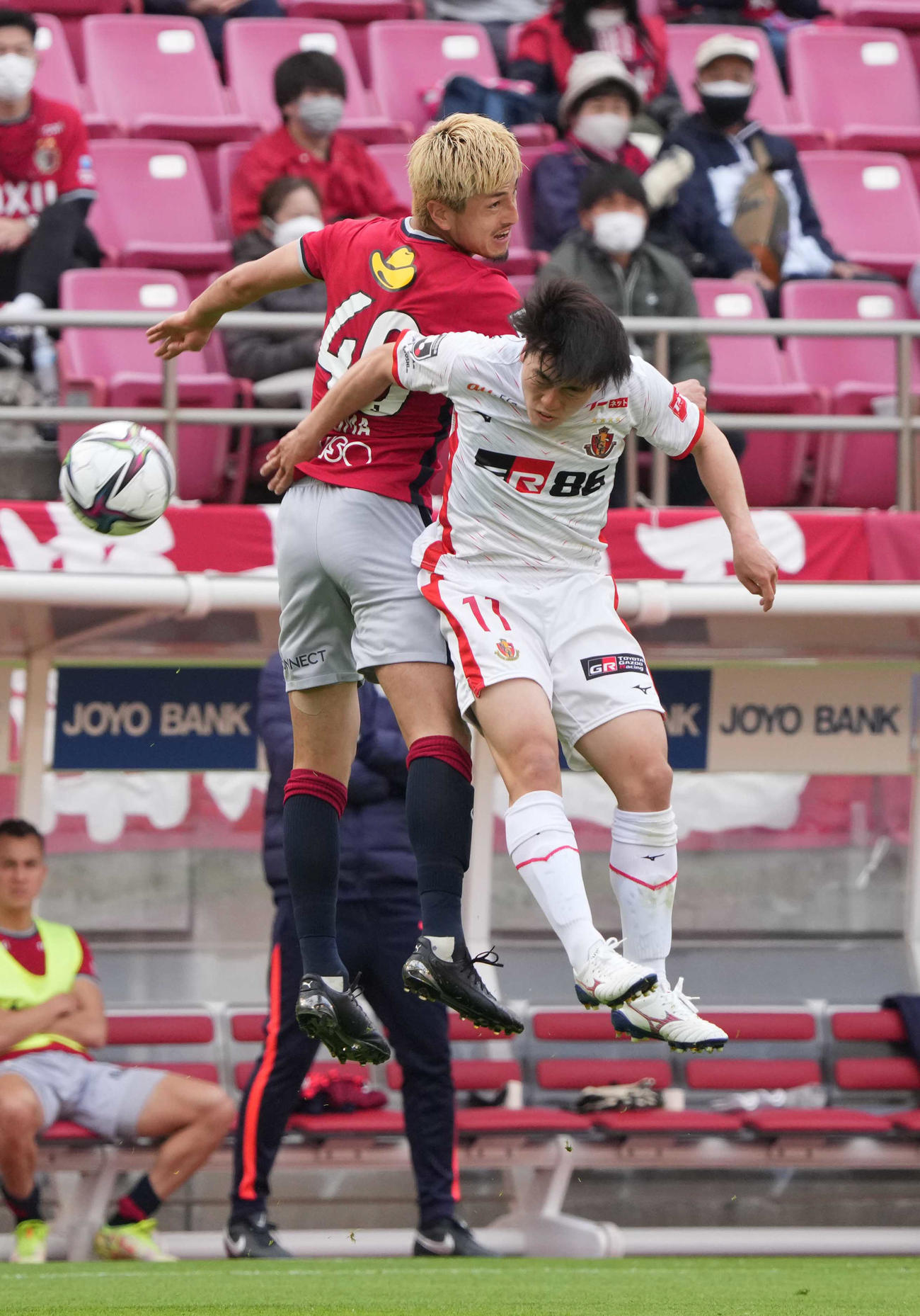 鹿島対名古屋　後半、浮き球を競り合う鹿島鈴木（左）と名古屋相馬（撮影・小沢裕）