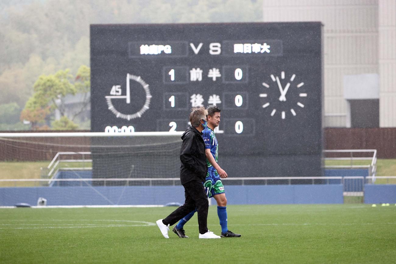 鈴鹿対四日市大　四日市大に勝利し鈴鹿・三浦監督（左）と話しながらピッチを引き揚げる鈴鹿カズ（撮影・上田博志）