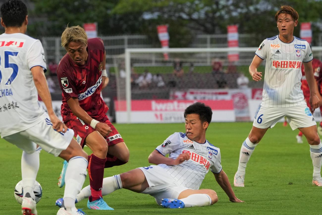 前半、琉球の選手と競り合う新潟高宇洋（中央）（沖縄タイムス提供）