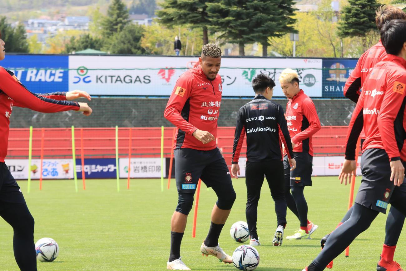 ランニング中にボールを蹴る札幌ドウグラス・オリヴェイラ（中央）（撮影・保坂果那）