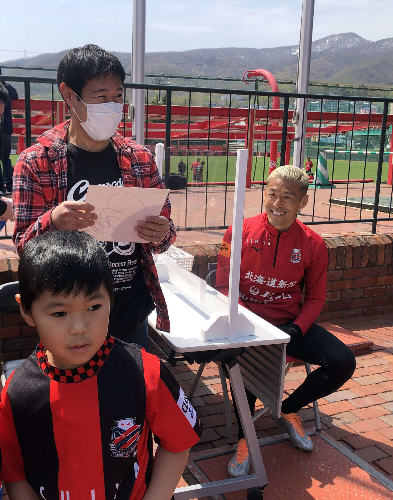 写真撮影会に参加したファンクラブ会員に笑顔を見せる札幌GK菅野（右）（撮影・保坂果那）