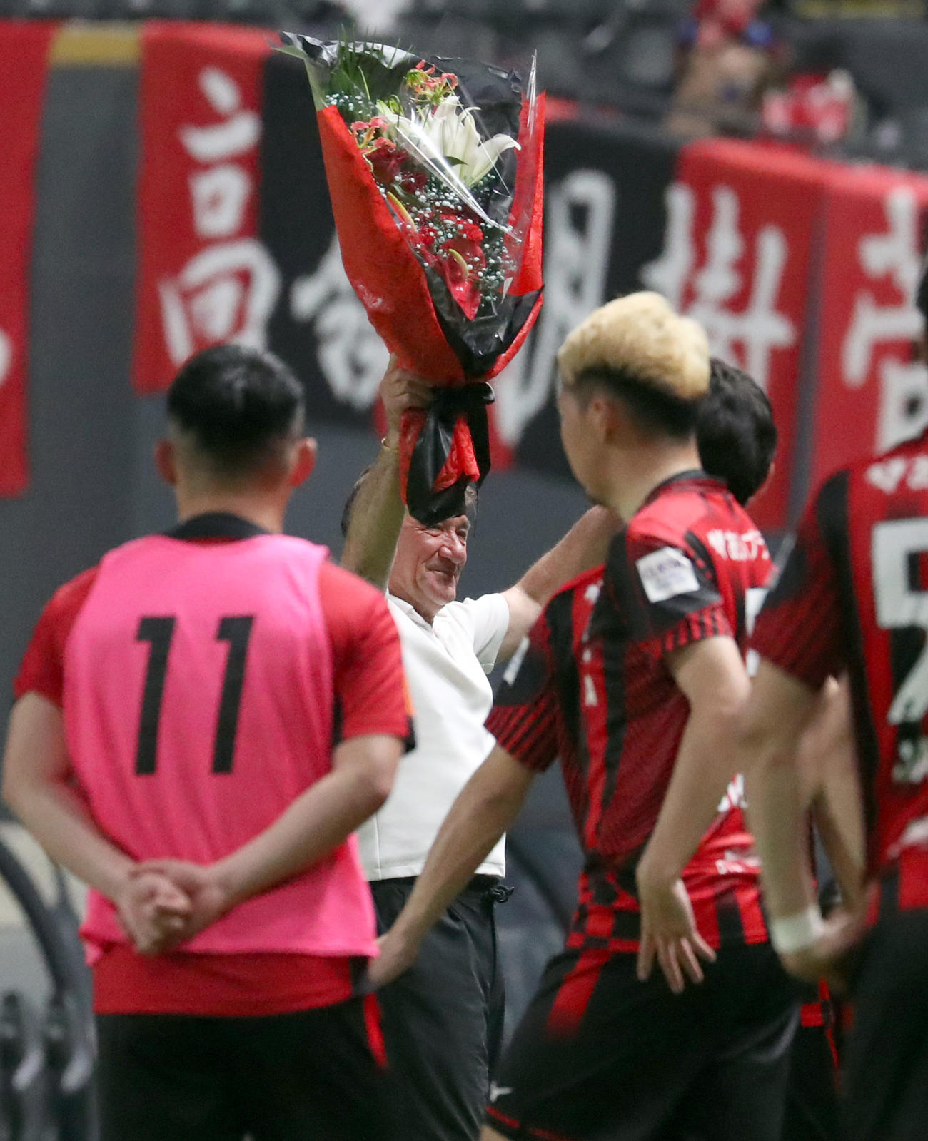 J1通算500試合を指揮した札幌ペトロビッチ監督は花束を贈呈され笑顔を見せる（撮影・佐藤翔太）