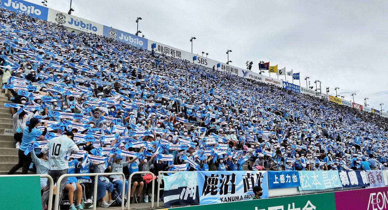 一斉観戦で訪れた磐田市内の小学5、6年生がタオルマフラーを掲げて応援する
