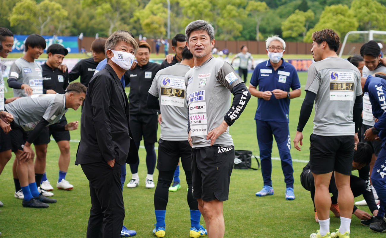 鈴鹿対HondaFC　会場スタンドを見つめる鈴鹿三浦カズ（中央・右）中央・左は鈴鹿三浦泰監督（撮影・森本幸一）