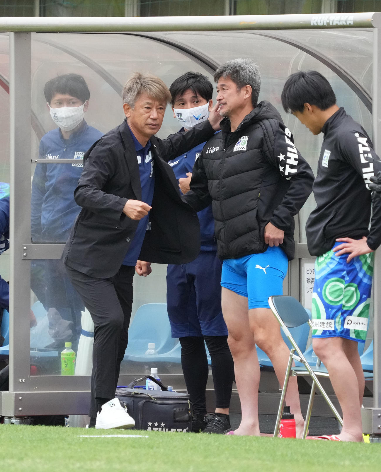 鈴鹿対HondaFC　試合終了、三浦知とタッチを交わす鈴鹿三浦泰監督（左）（撮影・森本幸一）