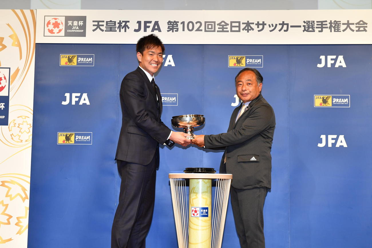 天皇杯を返還した昨年度優勝チーム浦和レッズ主将のGK西川周作（左）。右は天皇杯実施委員会の中野雄二委員長（C）JFA