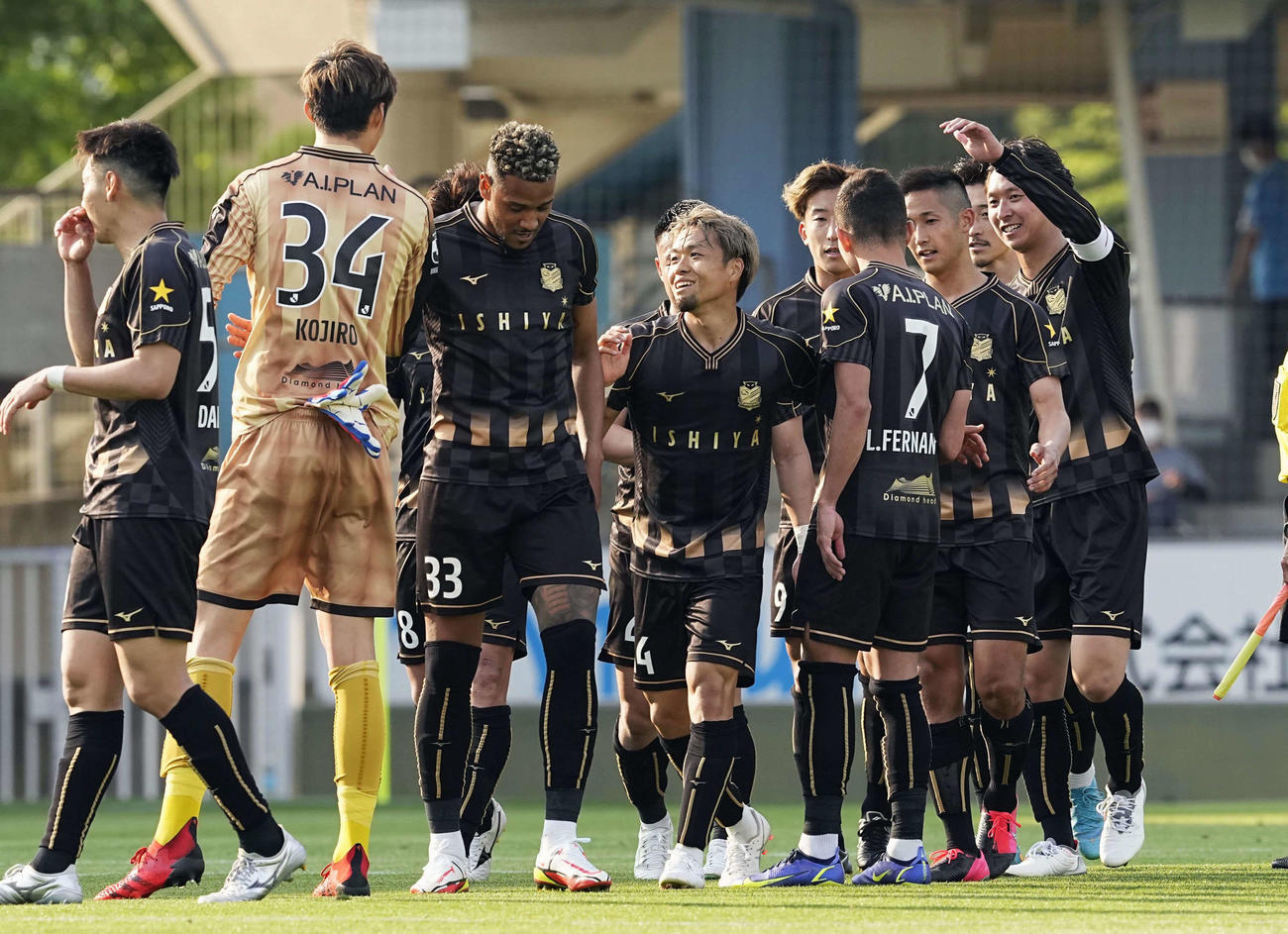 磐田に逆転勝ちし、タッチを交わす駒井（中央）ら札幌イレブン（共同）