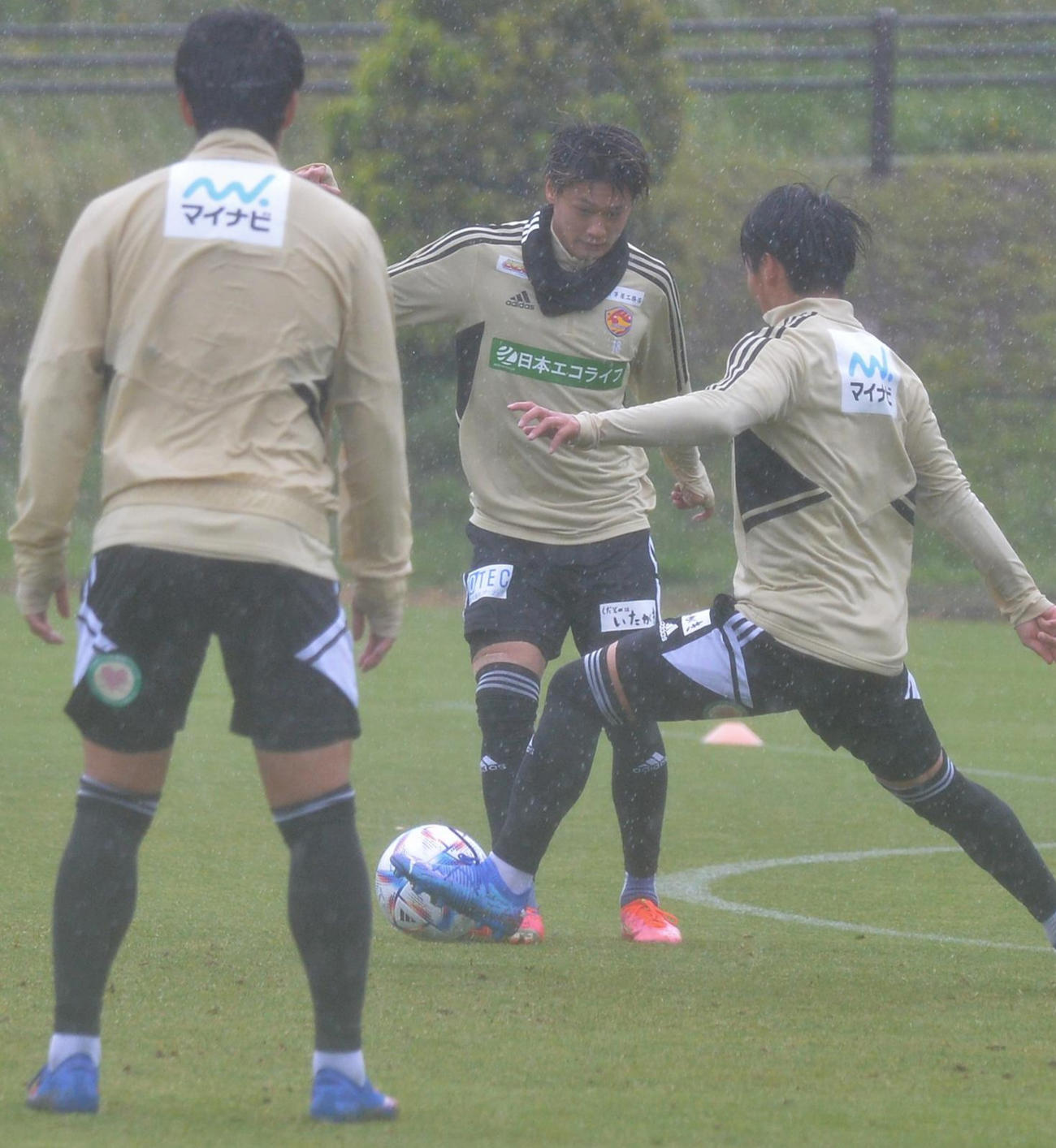 雨が降りしきる中、ボール回しをする気田（奥）