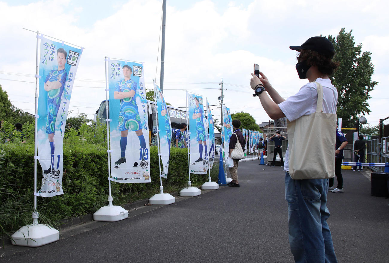 鈴鹿対大分　選手バスには乗っておらず、三浦のノボリを記念撮影するサポーターの姿も（撮影・加藤哉）
