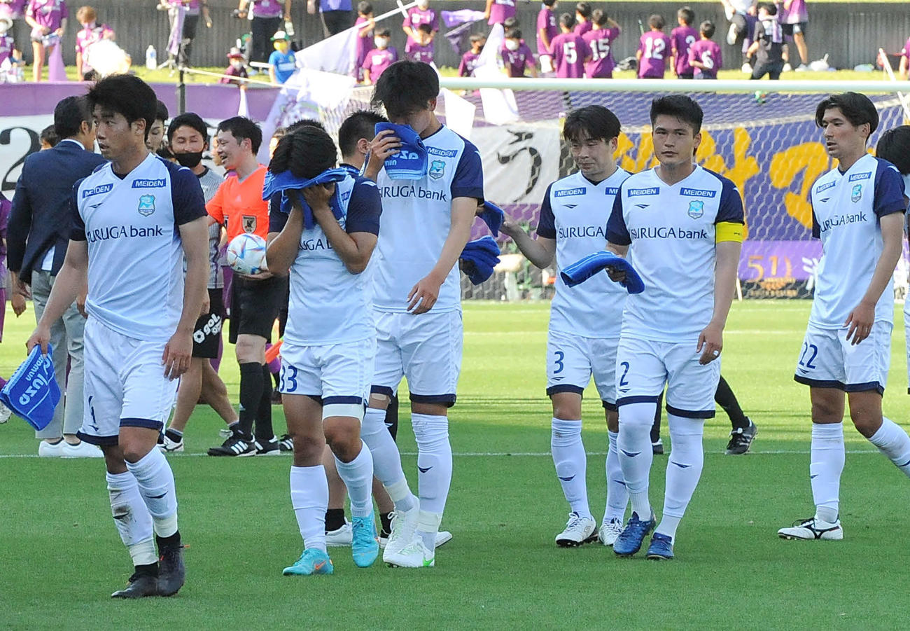 試合に敗れてピッチを後にする沼津の選手ら