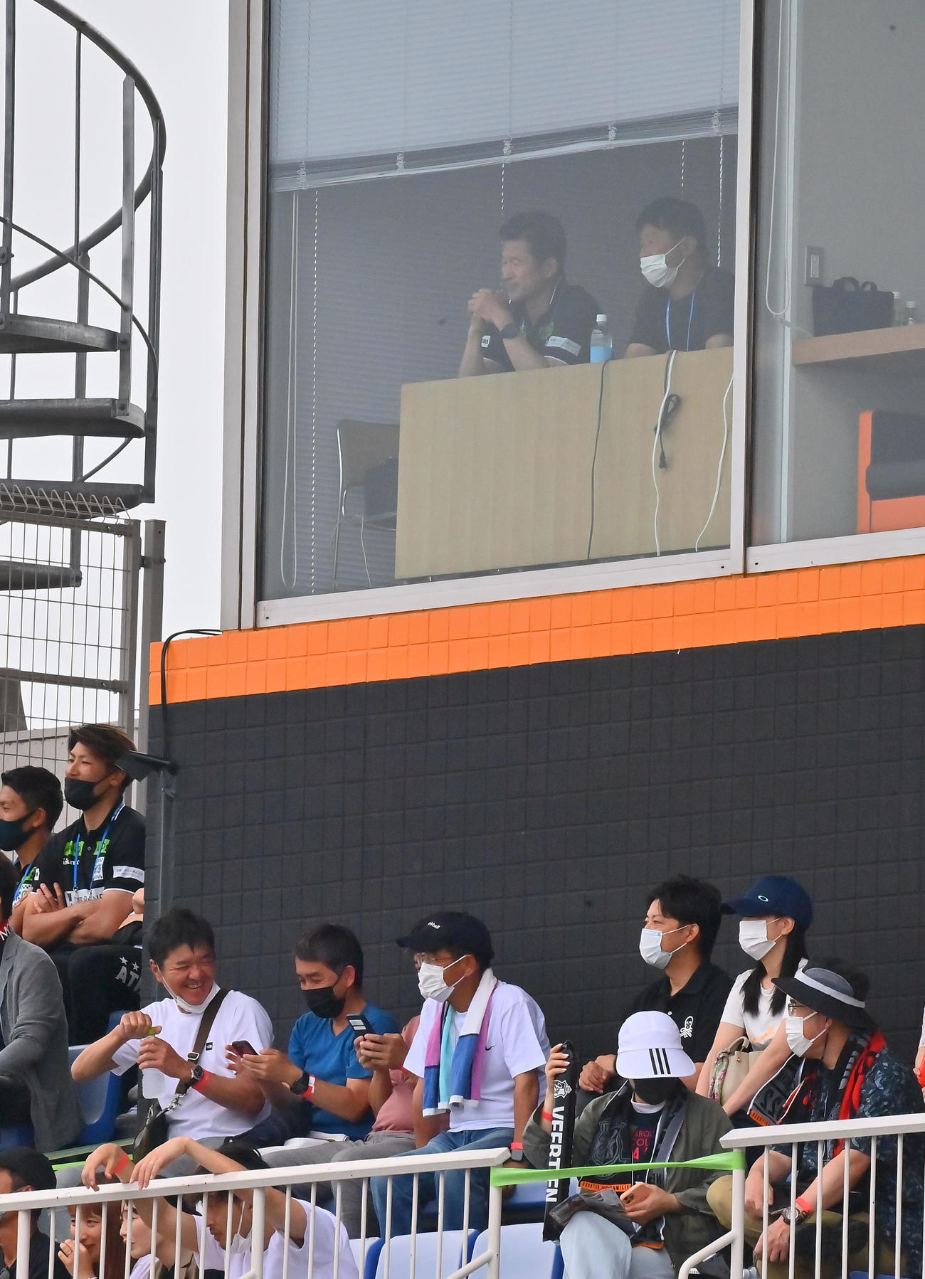 三重対鈴鹿　会場から窓越しに試合を見る武田氏とカズ（撮影・和賀正仁）