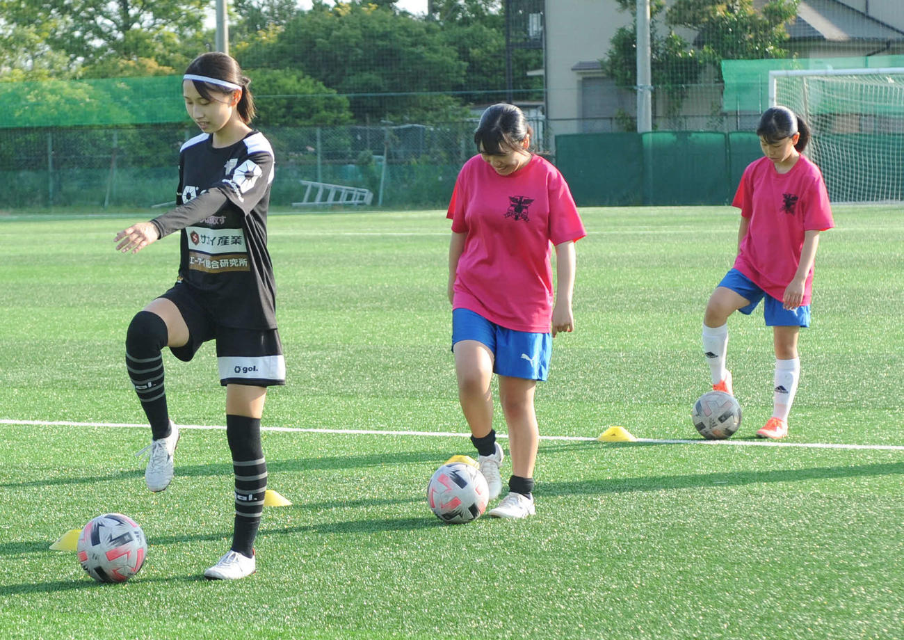 ルクレMYFCの選手（左端）の指導を受けながら、ドリブルを練習する高洲中の2選手