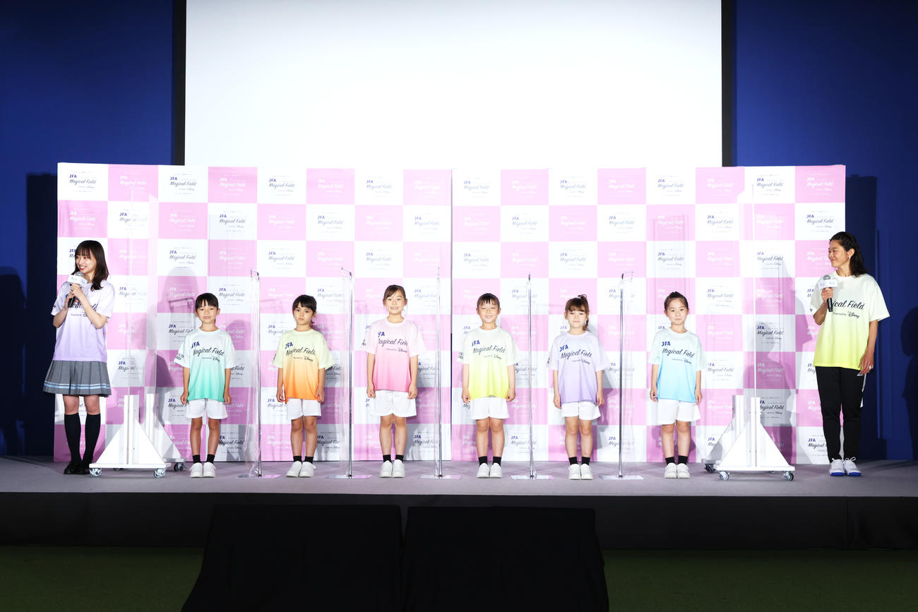 ユニホームを着たキッズモデルと登場した日向坂46影山優佳（左端）と元サッカー女子日本代表の澤穂希さん（右端）（C）Disney JFA Magical Field Inspired by Disney