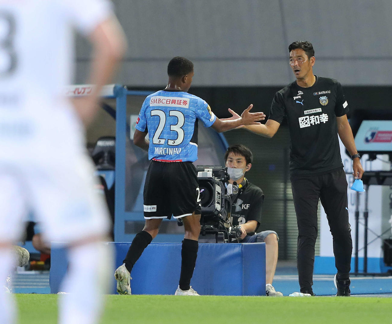 川崎F対G大阪　後半、ピッチから下がるマルシーニョ（左）とハイタッチする川崎F寺田コーチ（撮影・河田真司）