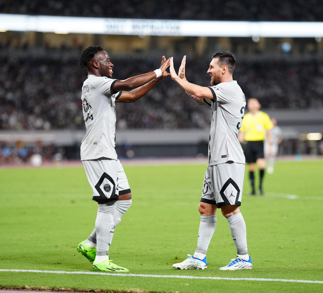 川崎F対パリ・サンジェルマン　後半、ゴールを決めたパリ・サンジェルマンのカリムエンド（左）とタッチを交わすメッシ（撮影・江口和貴）