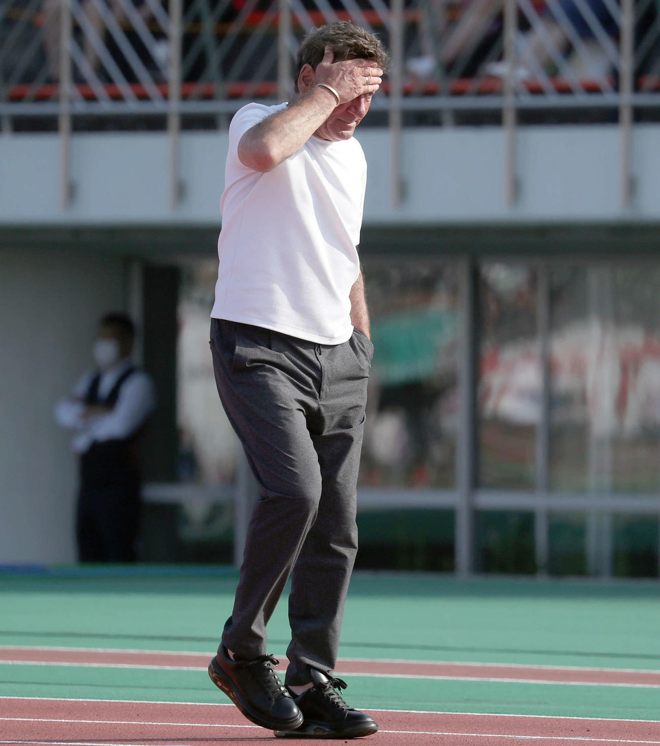 引き分けに終わり頭を抱えながら引き揚げるペトロビッチ監督（撮影・佐藤翔太）