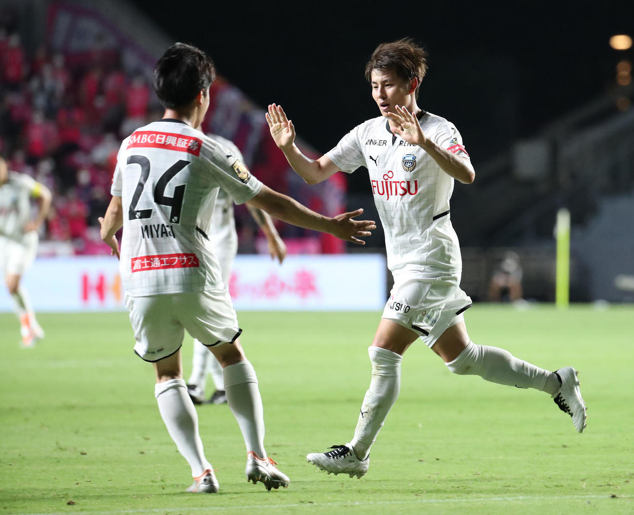 C大阪対川崎F　前半、先制ゴールを決めた川崎F脇坂（右）は宮城とタッチを交わす（撮影・白石智彦）