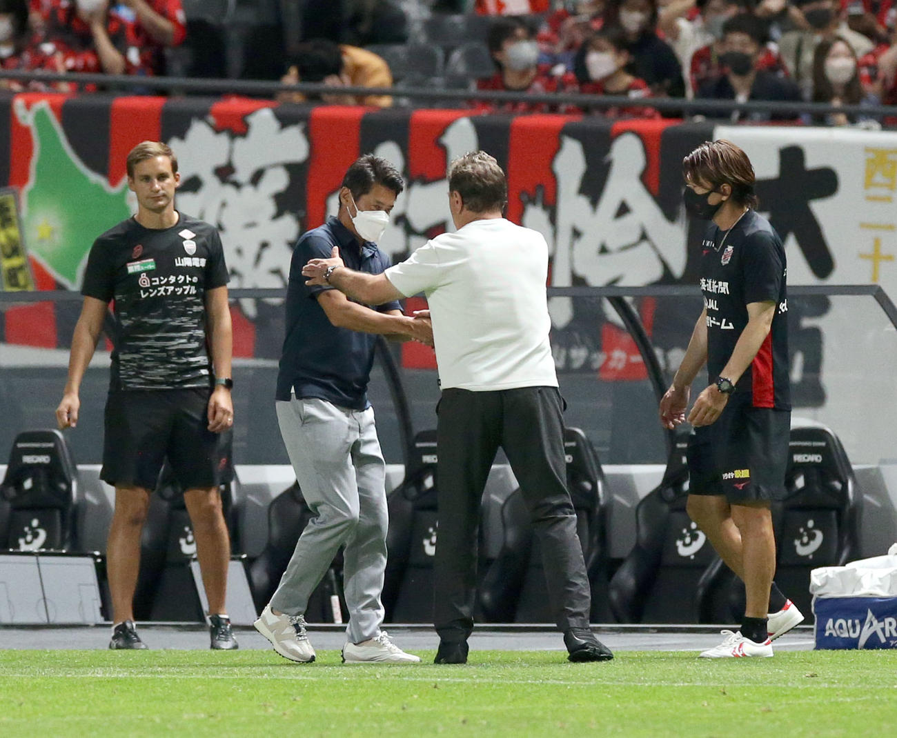 札幌対神戸　試合終了後、神戸吉田監督（中央左）は札幌ペトロビッチ監督と握手を交わす（撮影・佐藤翔太）