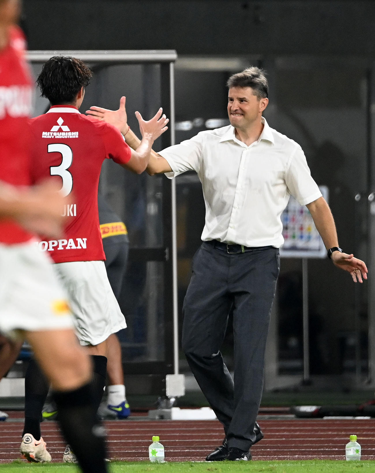 磐田対浦和　後半、ゴールを決めた浦和伊藤（左）とタッチを交わすリカルド・ロドリゲス監督（撮影・横山健太）