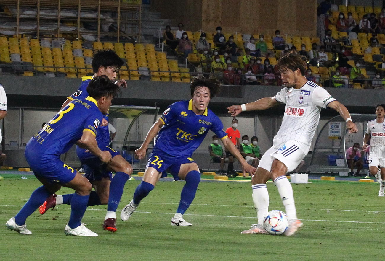 前半40分、相手3人に囲まれながら左足で先制点を奪った鈴木（右）